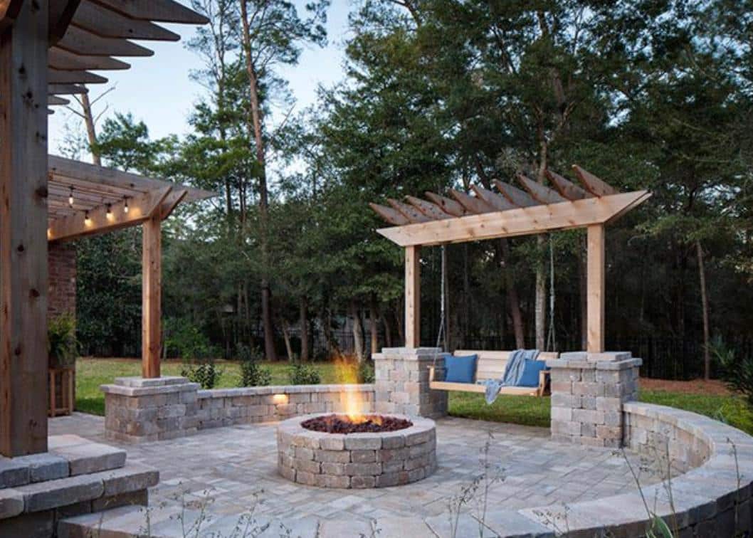 A backyard with a fire pit and a swing.